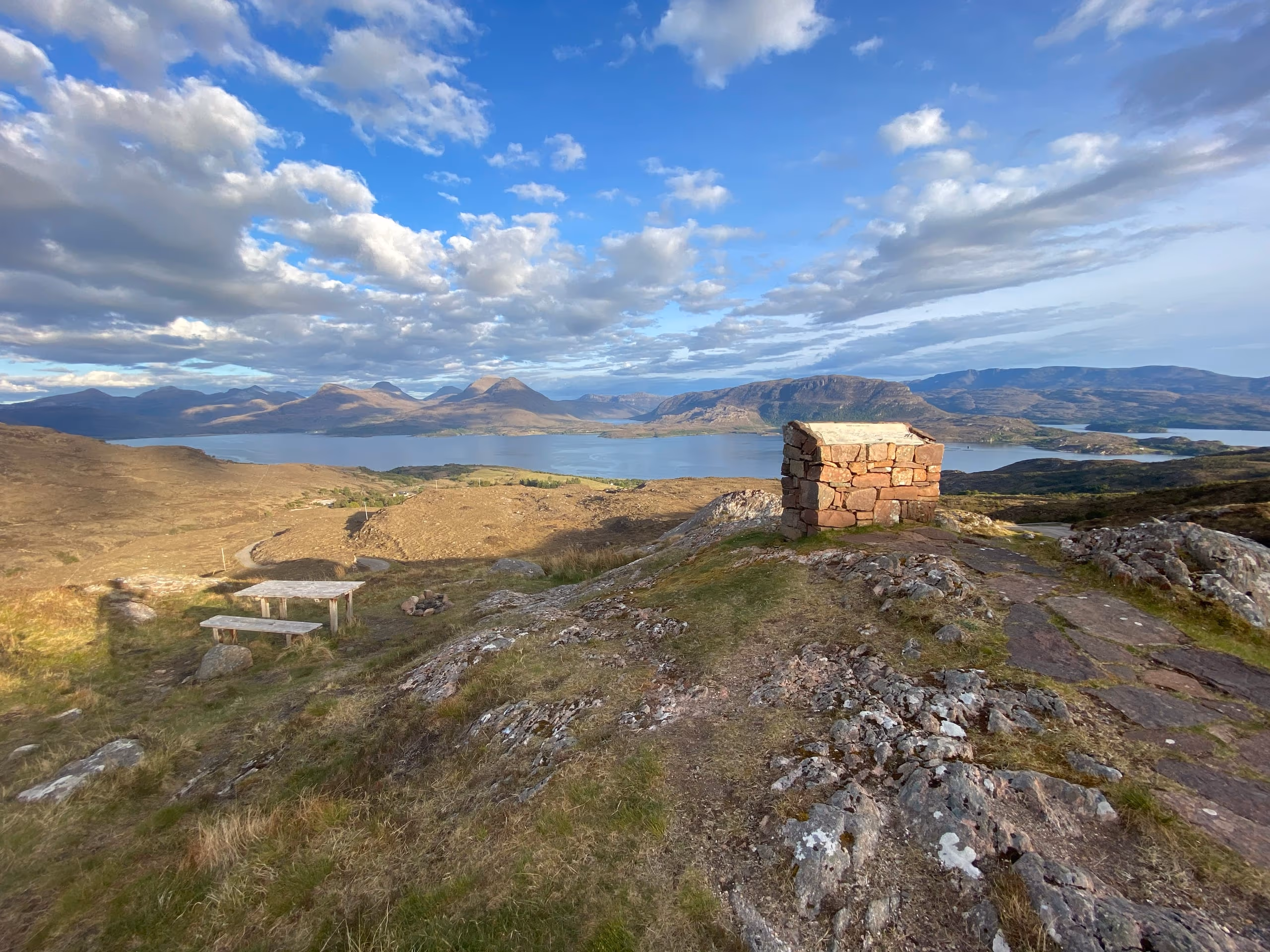 A stone cairn on a ridge above Applecross, the sea and the hills laid out beyond it under a big sky