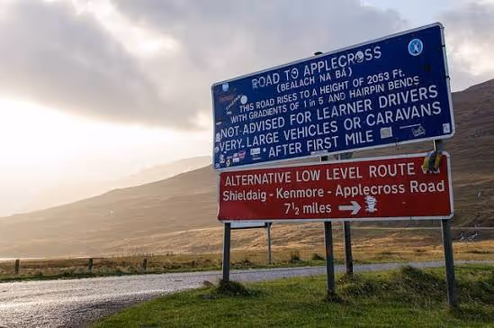 The sign at the foot of the pass: the road rises to 2053 feet, gradients of 1 in 5 and hairpin bends, not advised for learner drivers or caravans