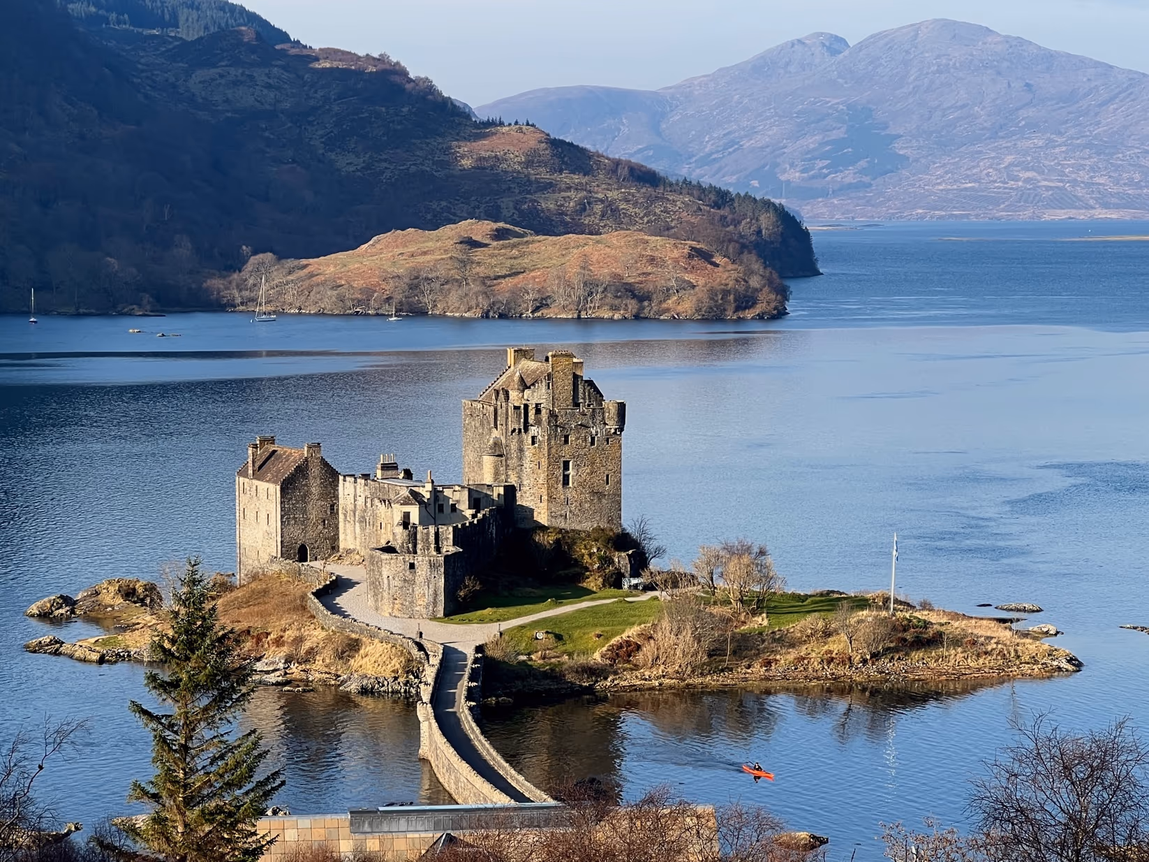 Eilean Donan on its island at Dornie, the causeway running out to it and the hills of Skye across the water beyond