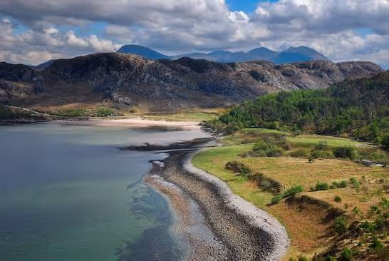 The pale sand and shallow water of Gruinard Bay, the hills of Wester Ross running back behind the shore