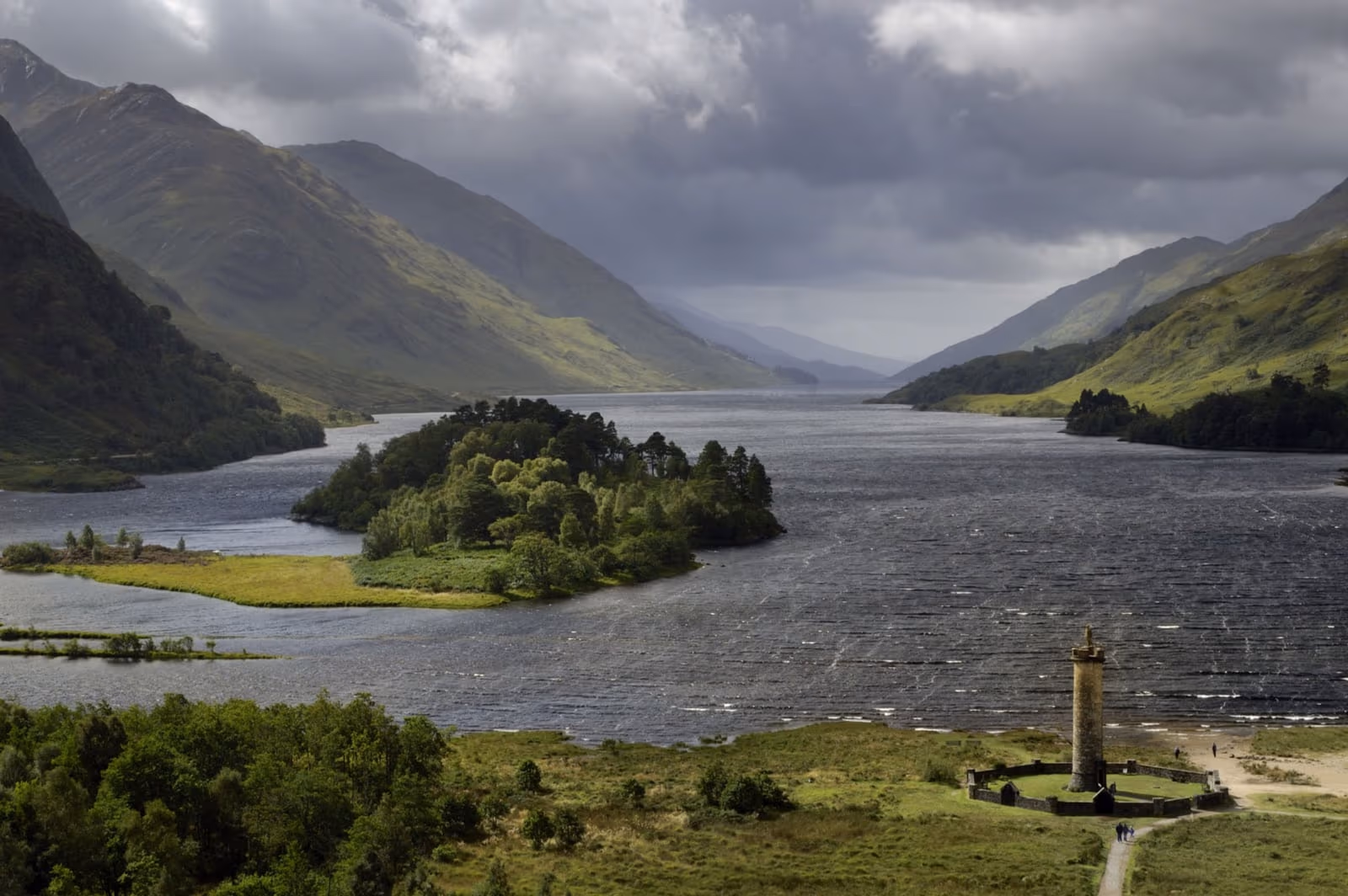 Loch Shiel from above Glenfinnan under broken cloud, the monument small on the shore and the loch running away between the hills