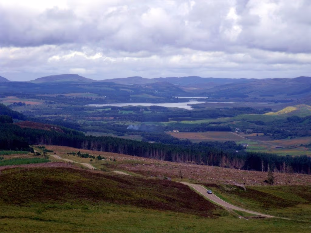 Heather and forestry falling away below the Suidhe viewpoint, the loch and the strath opening out under heavy cloud
